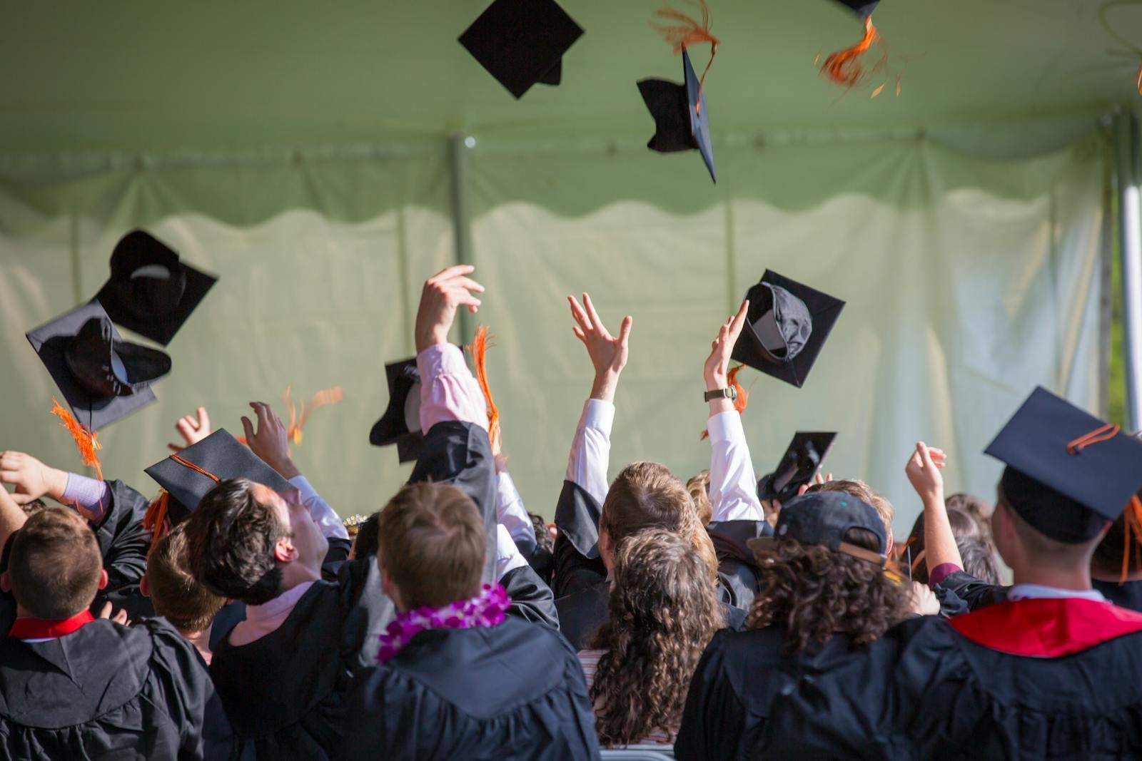 Students actively participate in a university lecture, raising hands and discussing topics.
