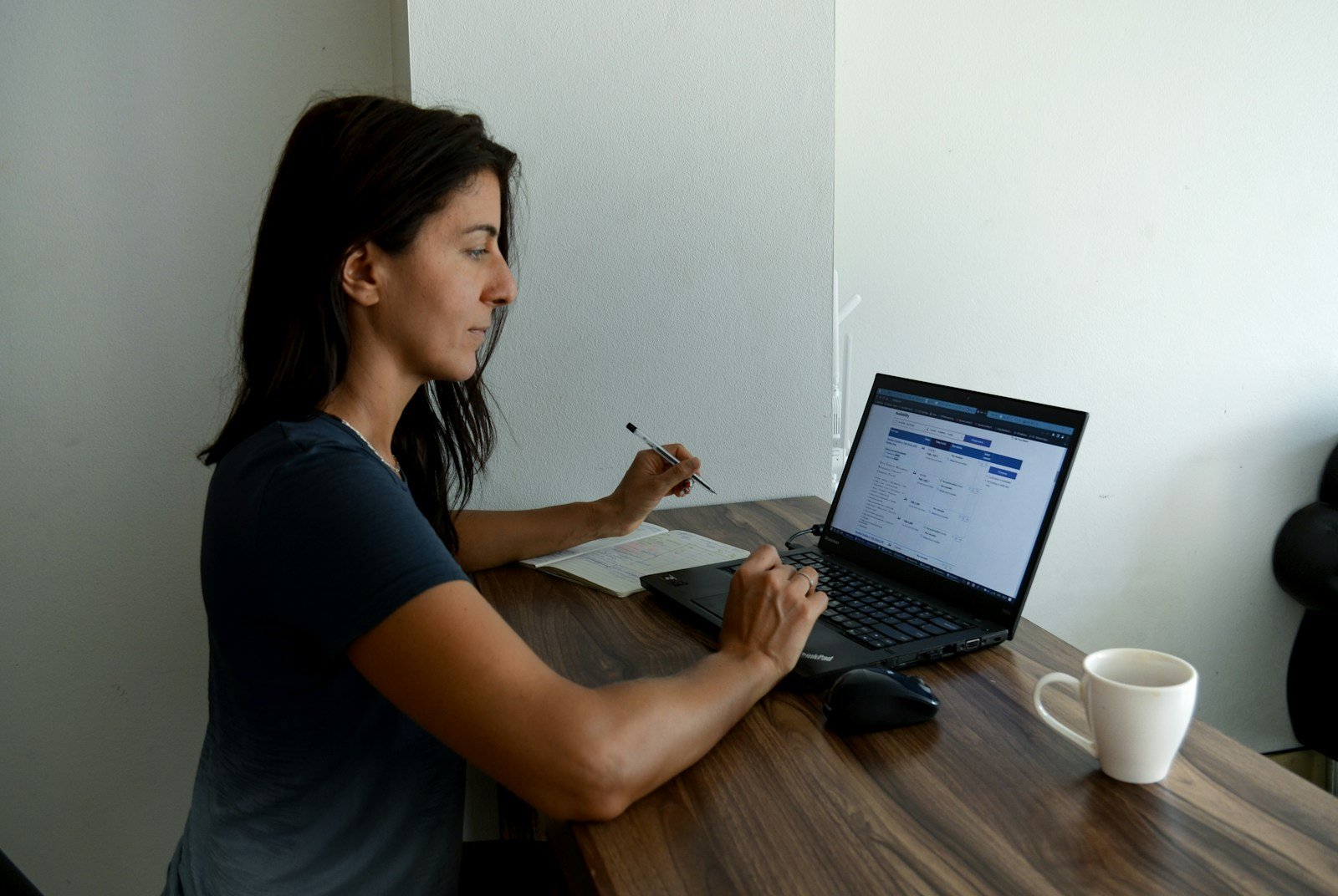 a woman sitting at a table with a laptop